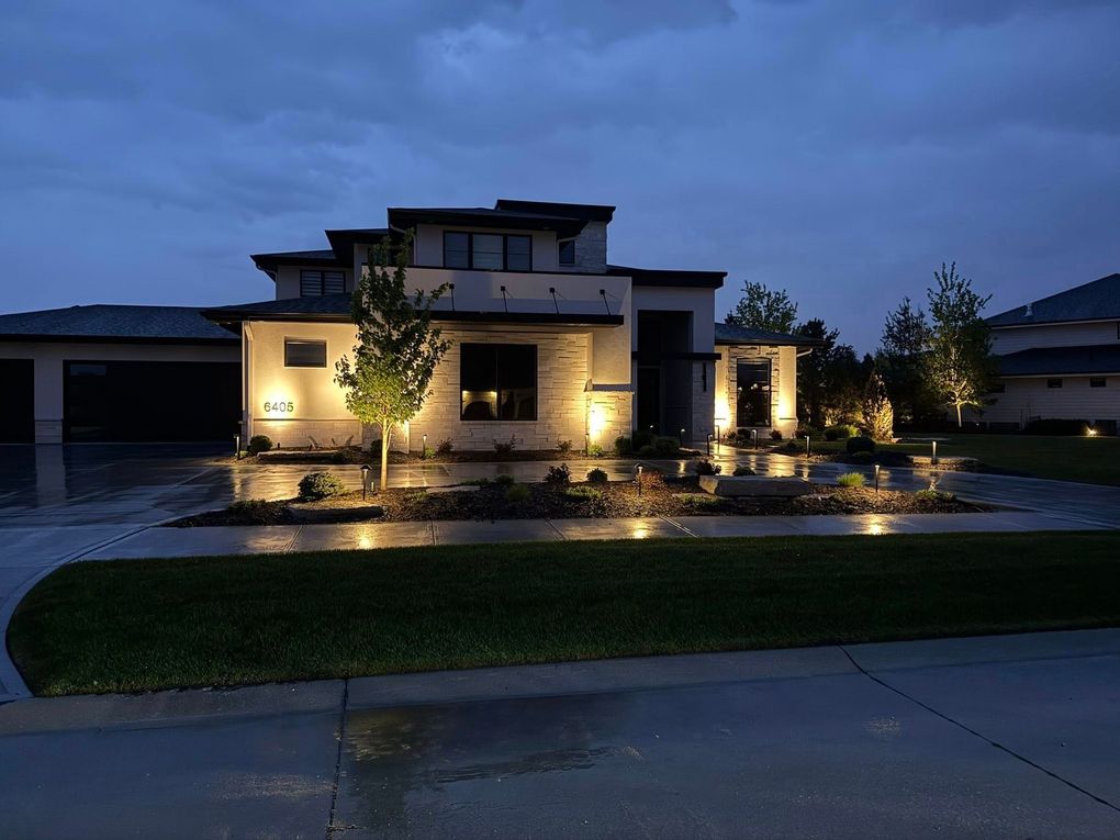 Omaha two-story house at dusk with warm exterior lights done by Earl Outdoor Solutions
