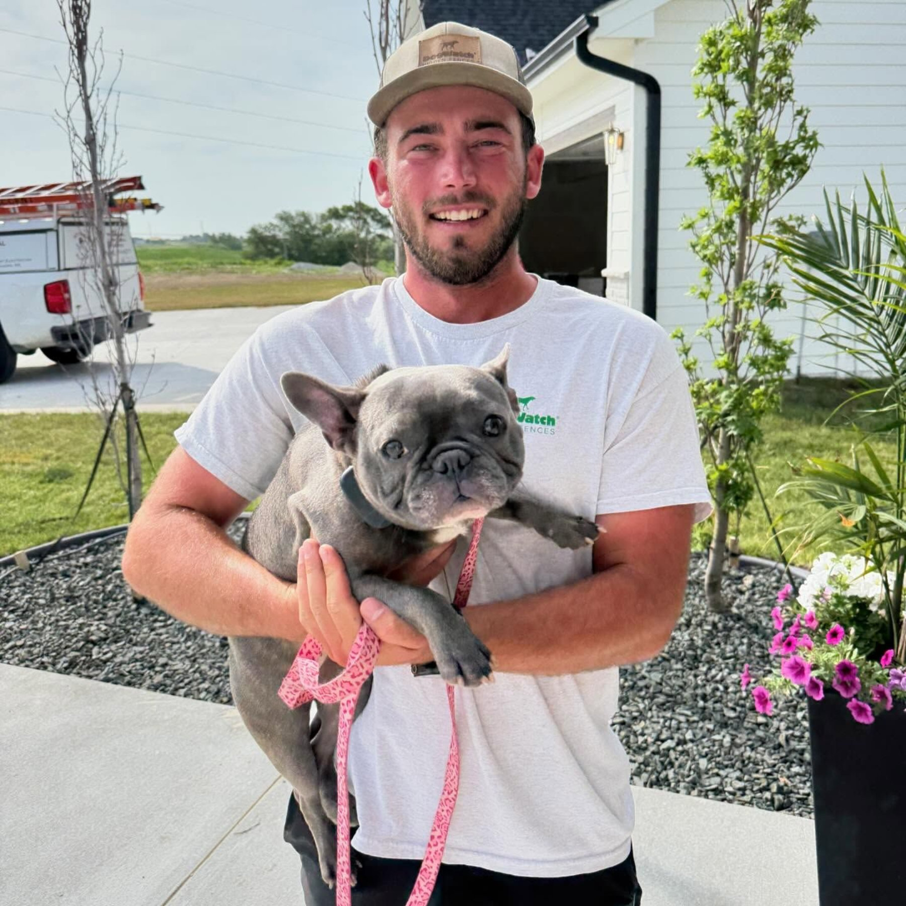 Earl Outdoor Solutions team member with French Bulldog after DogWatch installation