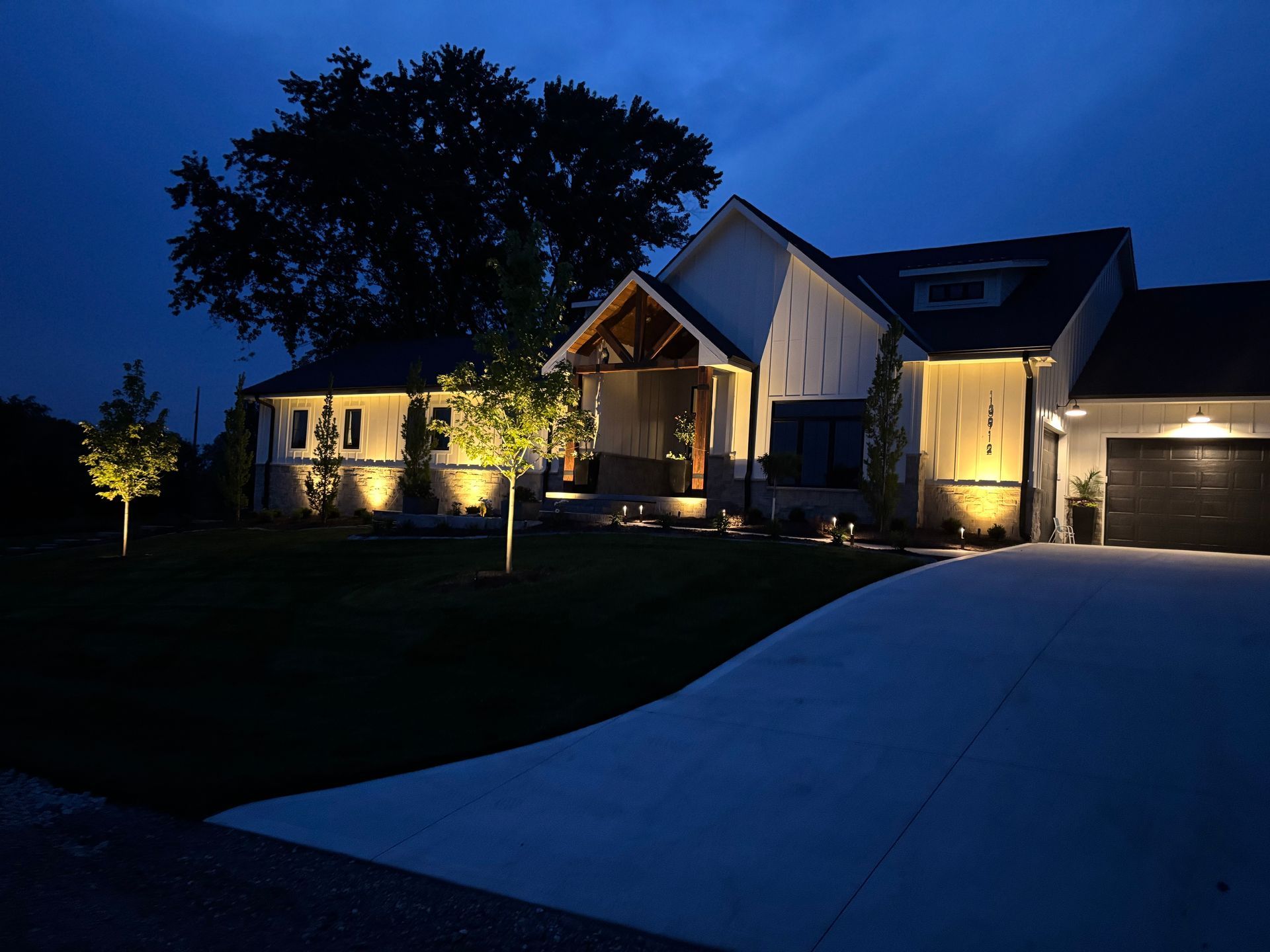 Alliance landscape lighting illuminating modern home exterior at night — Omaha NE