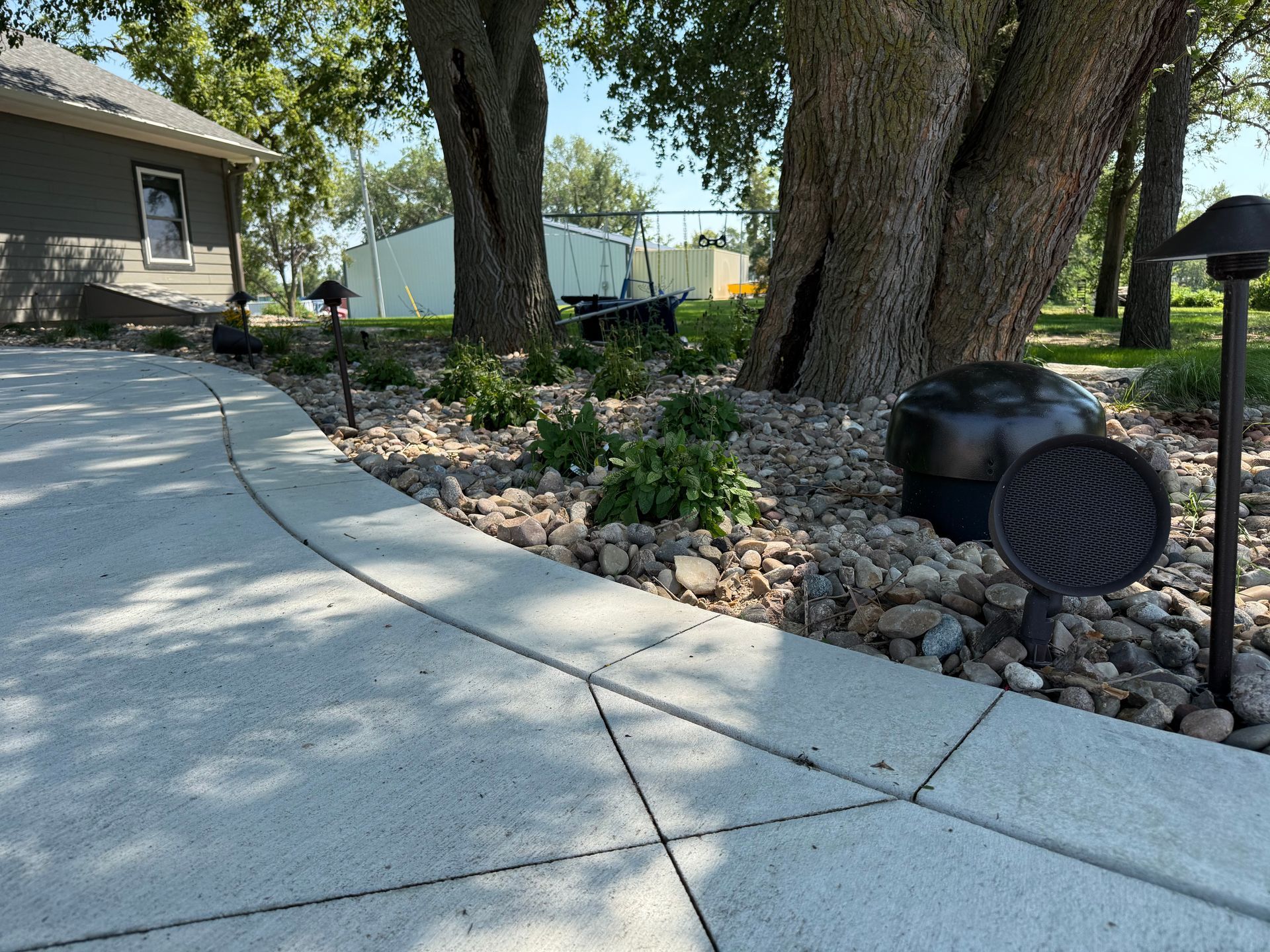 Landscape lighting along curved driveway with mature trees — Omaha Nebraska
