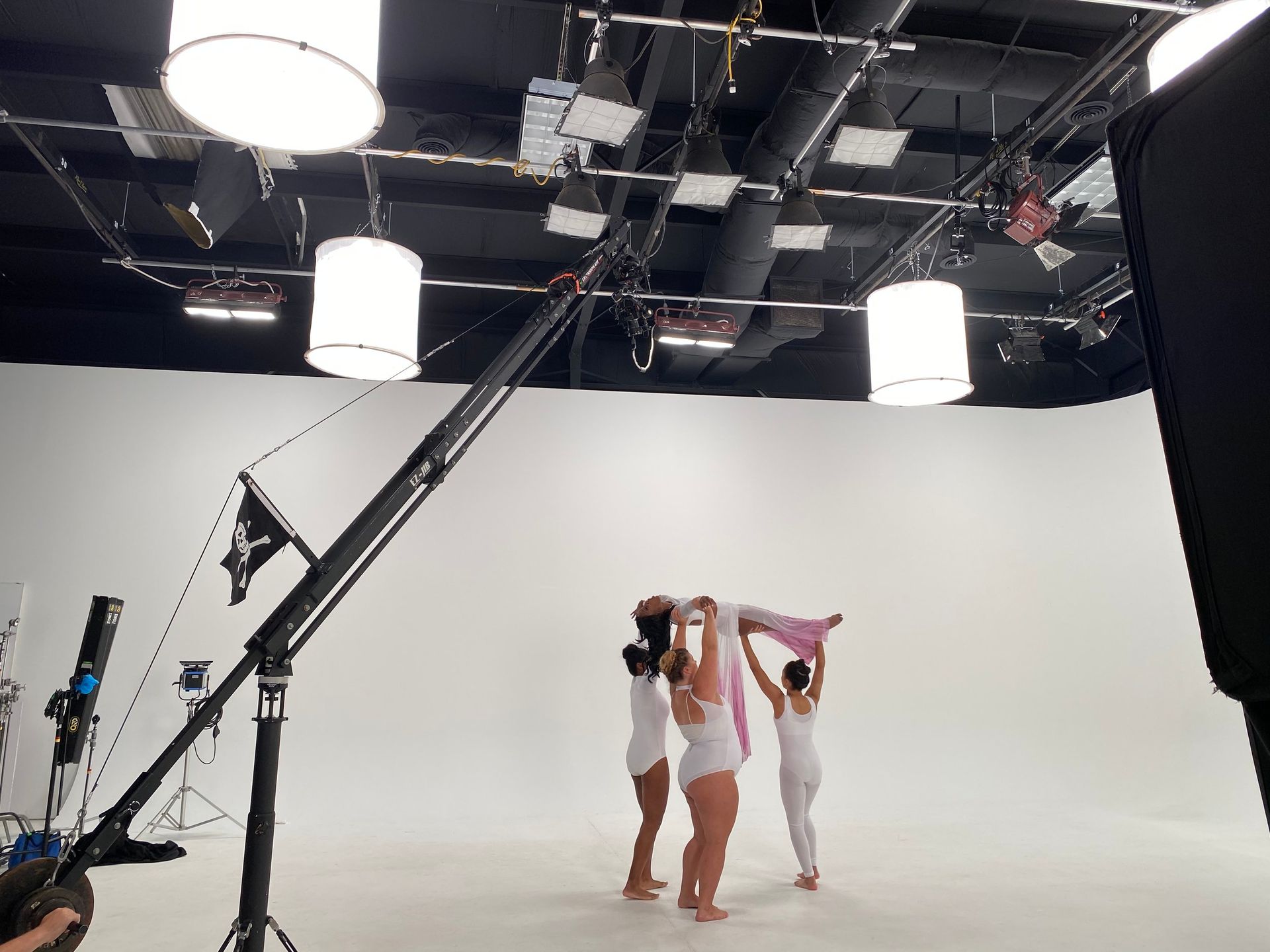 A group of women are dancing in a studio with a crane in the background