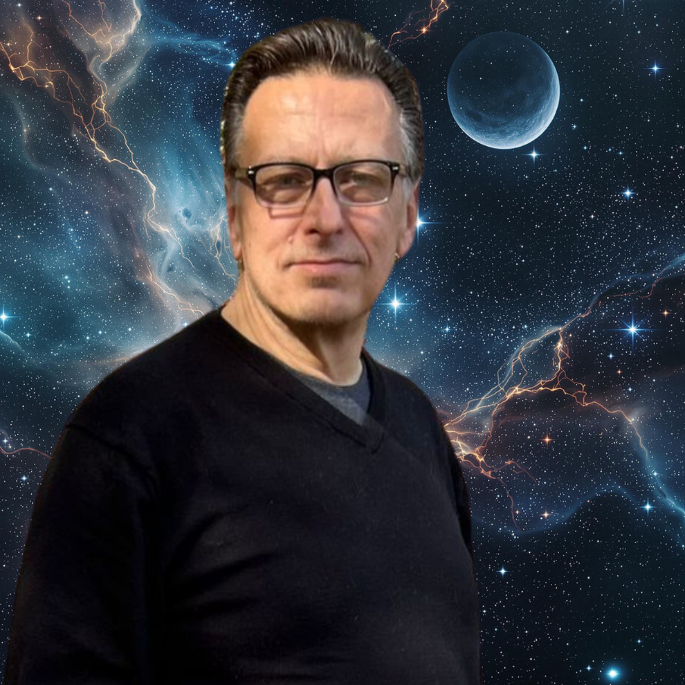 Dave Johnson wearing a black V-neck sweater and  glasses stands in front of a space background. 