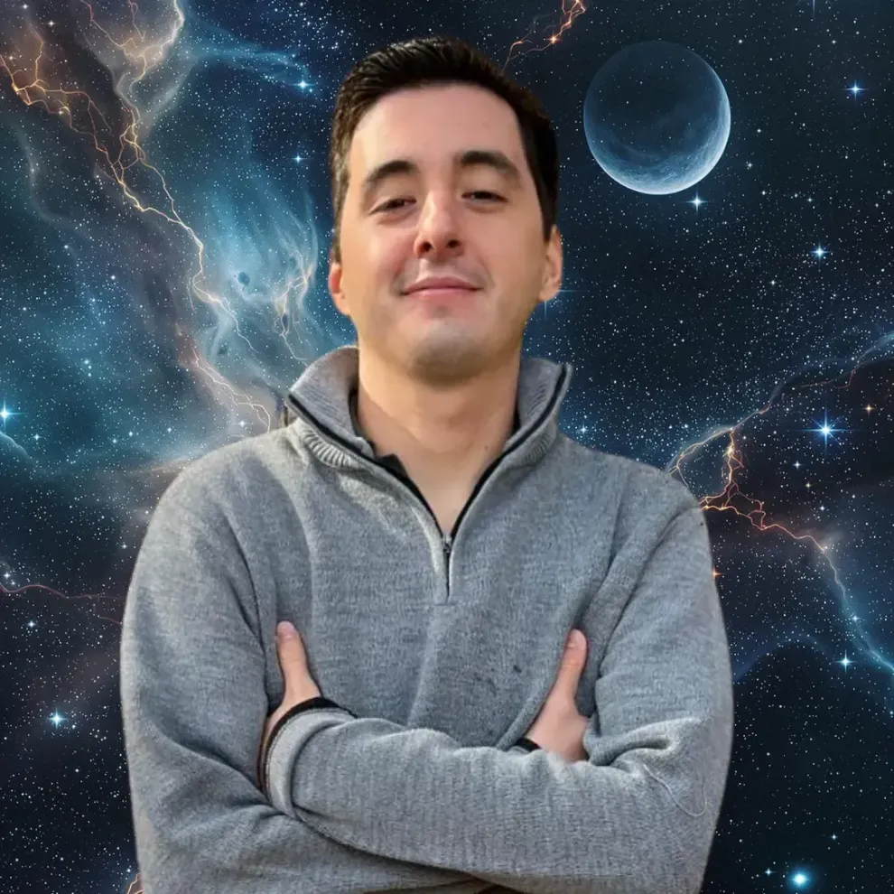 Emilio Ayala with his arms crossed in front of a space background