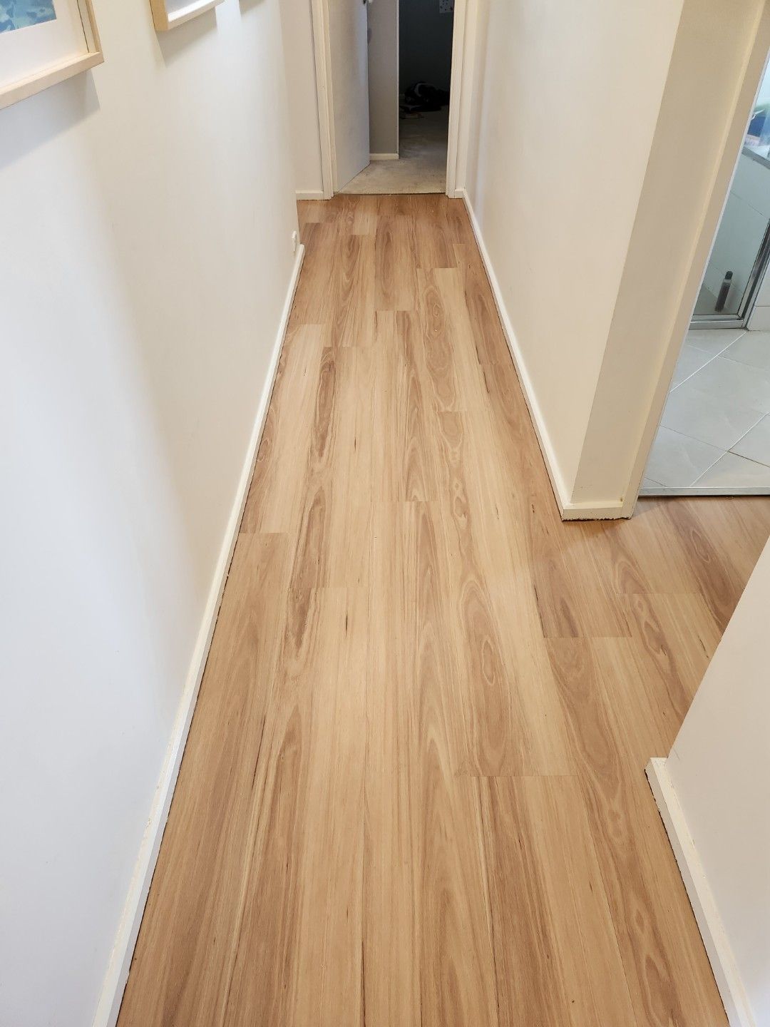 Narrow Hallway with Light Wood-Look Flooring and White Walls — Canberra Floor Coverings in Queanbeyan West, NSW