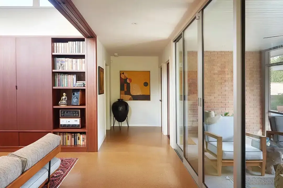 Hallway with Wooden Floor, Bookshelves, Artwork — Canberra Floor Coverings in Queanbeyan West, NSW
