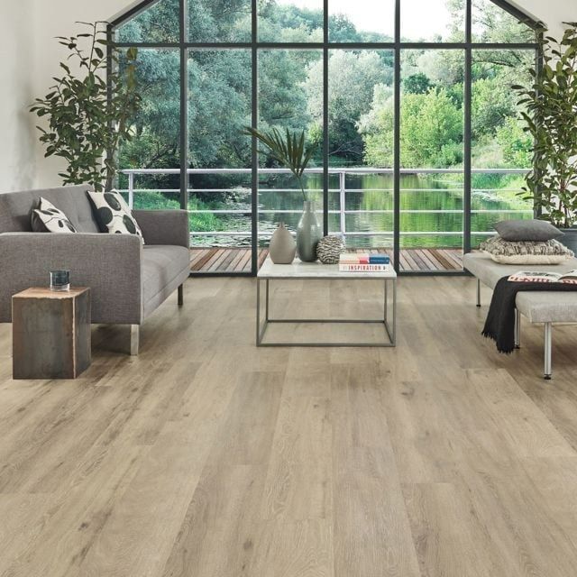Living Room With Wood Flooring and Grey Sofa — Canberra Floor Coverings in Queanbeyan West, NSW