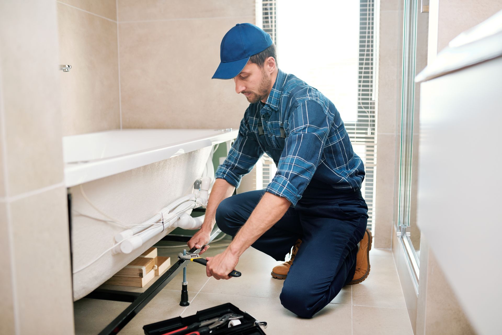 Technician carefully planning and preparing the installation of a bathtub, reviewing intricate details and measurements.