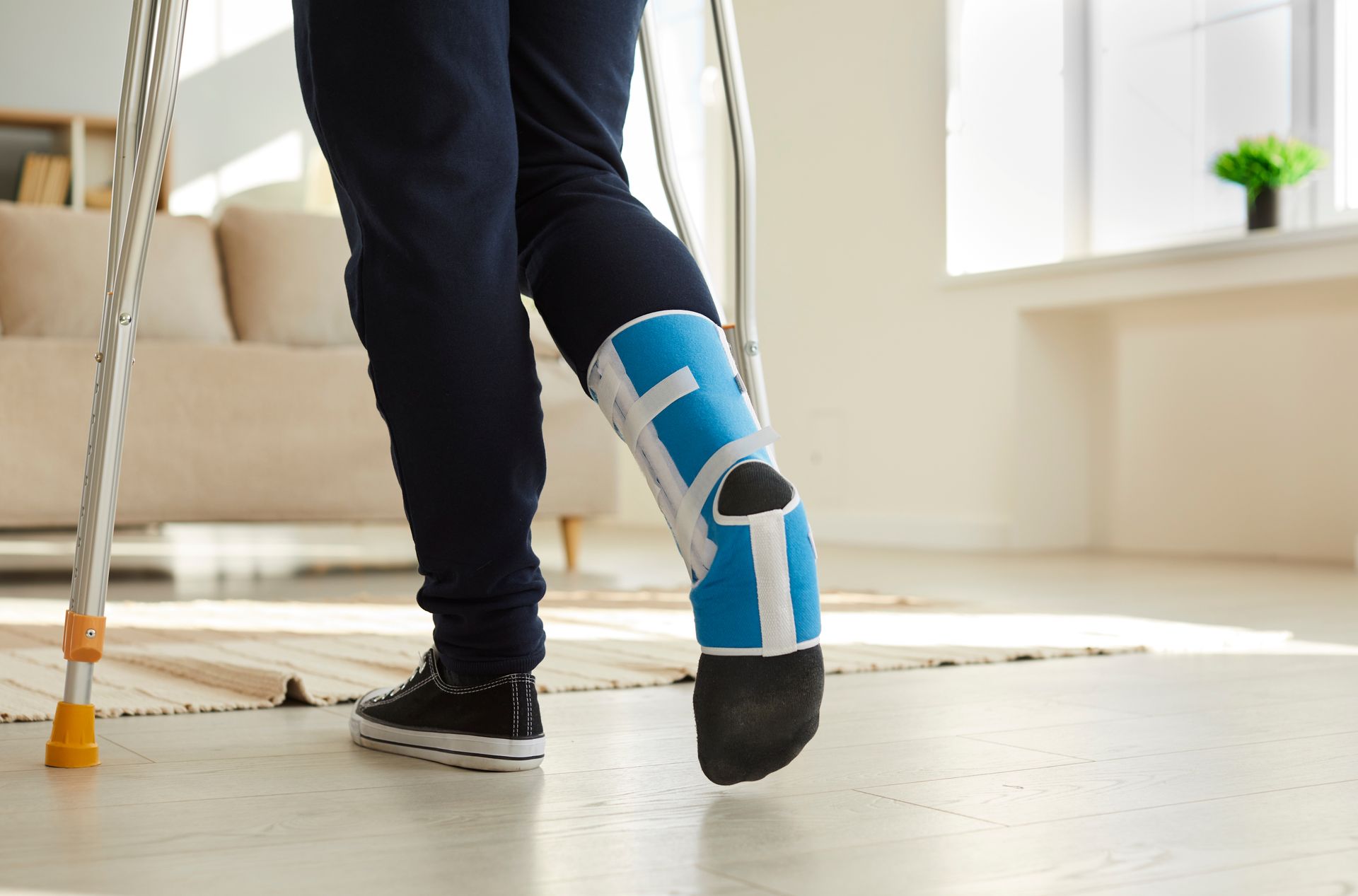 Person with a leg brace and crutches indoors.