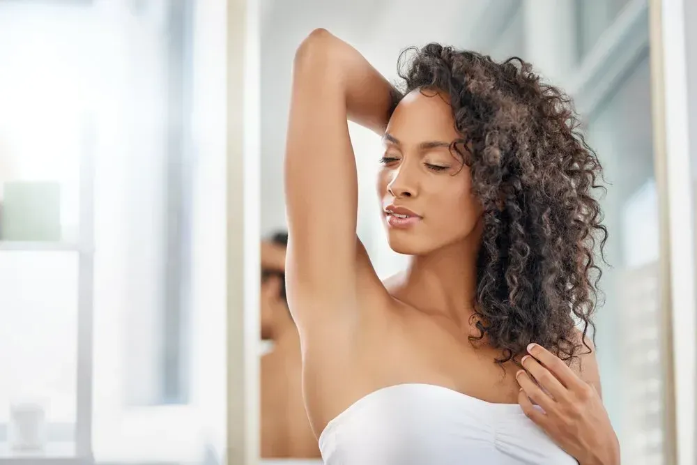 young woman smelling her armpits