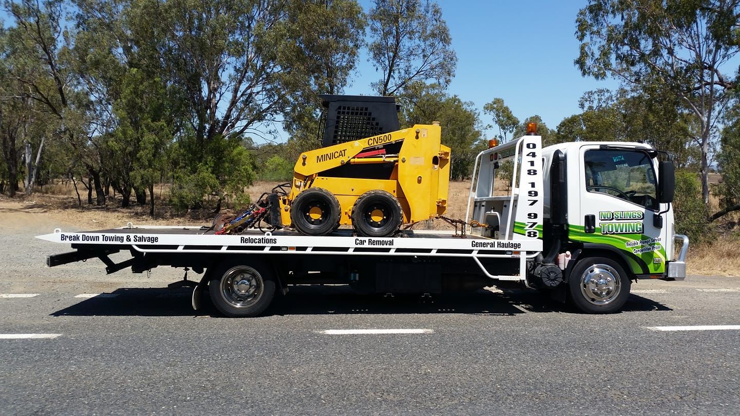 Yellow Skid Steer Loader Secured on a Flatbed Tow Truck — No Slings Towing in Glendale, QLD