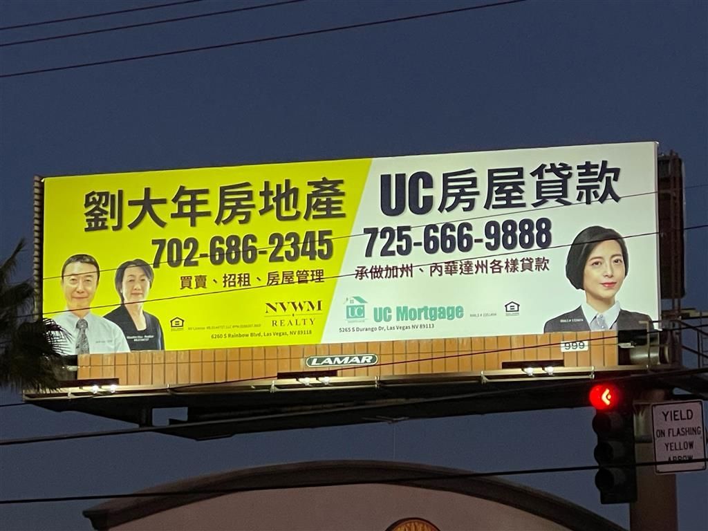 Chinese real estate billboard with phone numbers on a street at dusk