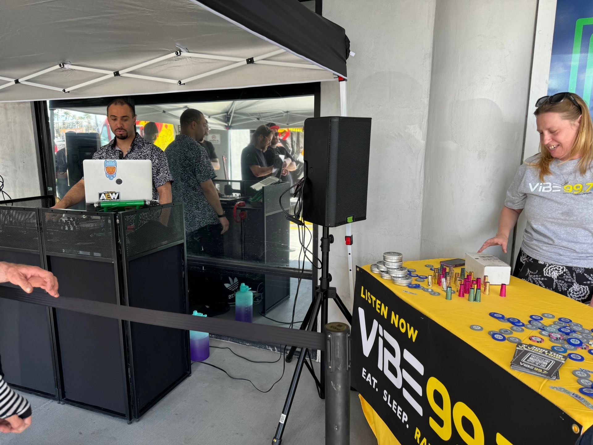 Vendor booth at an outdoor event with a laptop table, black canopy, and yellow VP display counter