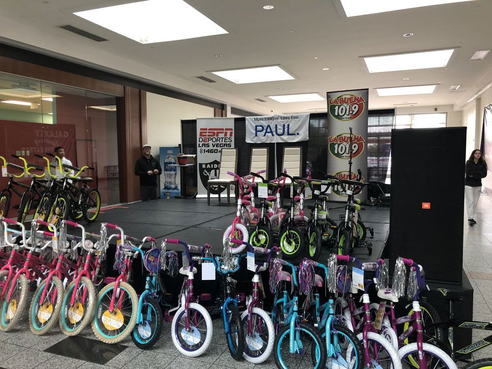 Indoor bike display with rows of colorful children’s bikes in a store or showroom, with a “PAUL” sign.
