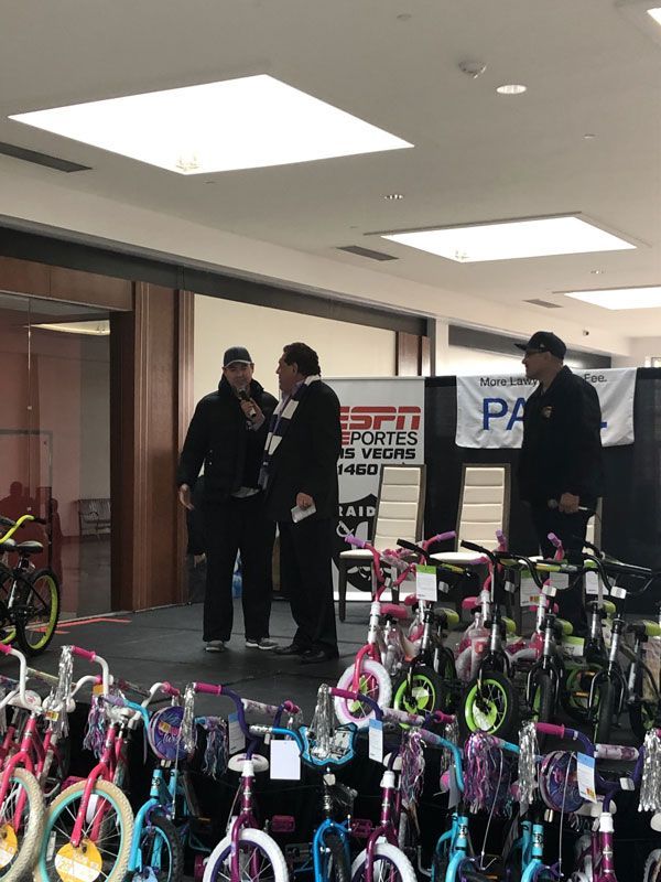 People standing beside rows of colorful bicycles indoors at an event booth.