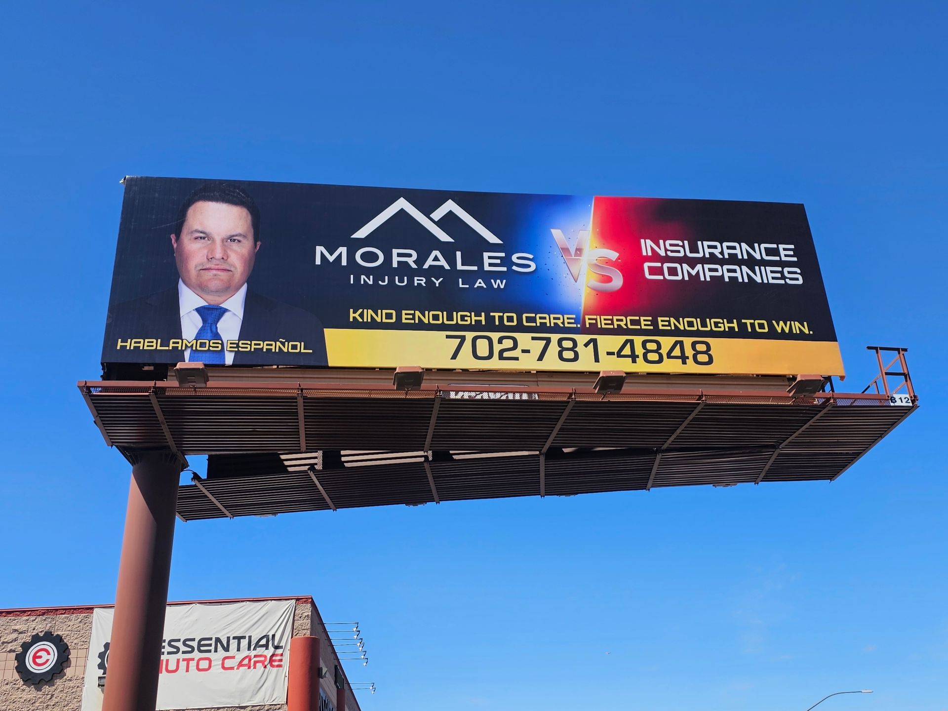 Billboard for Morales Insurance, with a suited man portrait and phone number against a blue sky.