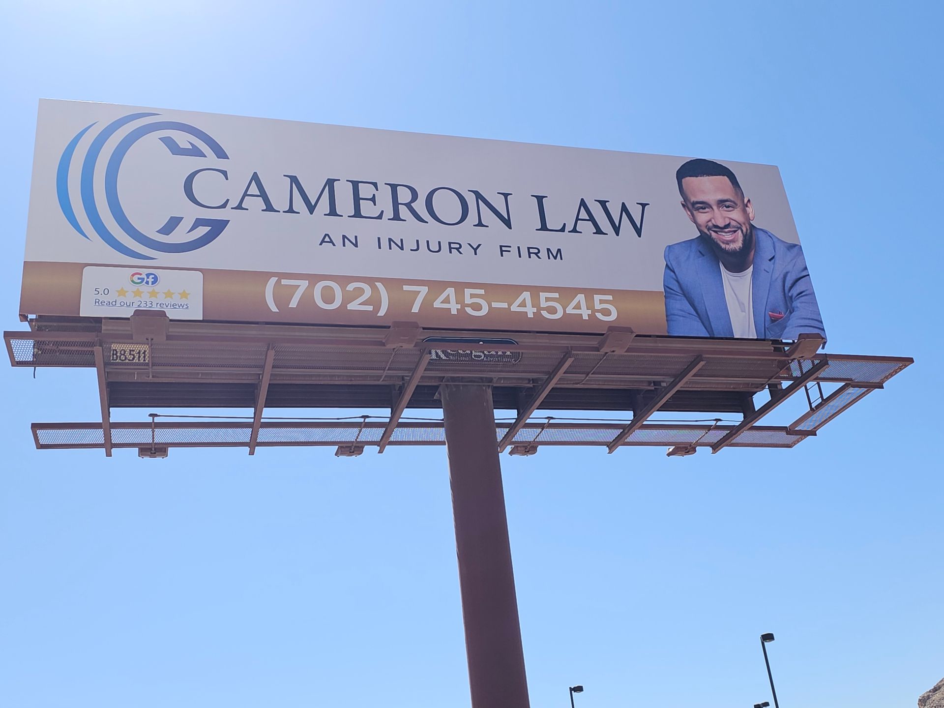 CAMERON LAW billboard with phone number and a smiling man on a blue sky background