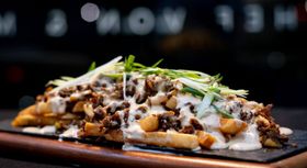 Smothered fries displayed on a cutting board