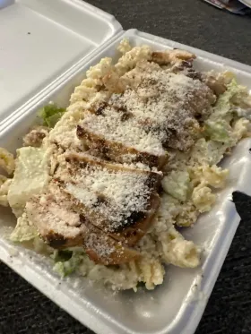 Chicken Caesar salad in a take out container