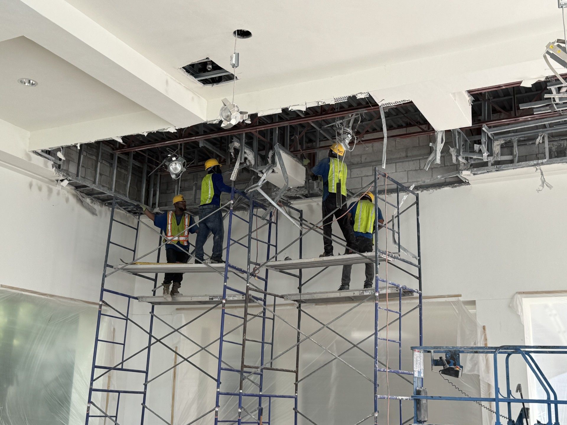 Commercial interior demolition of a South Florida retail or office space performed by Dr. Rubble, structural elements exposed, workers in PPE.