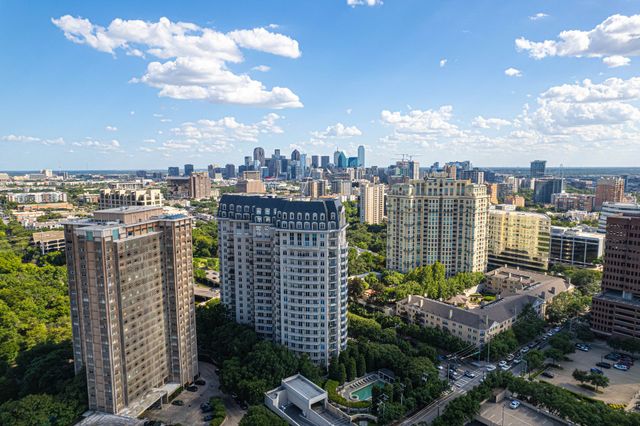City skyline with high-rise apartments under a bright blue sky and scattered clouds
