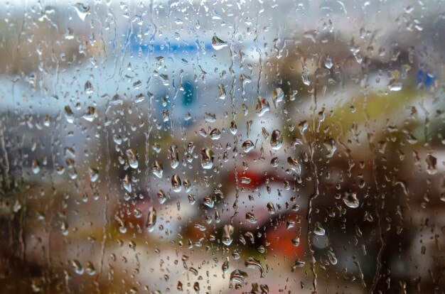 Close-up of raindrops on a glass window, illustrating the importance of waterproofing to prevent water damage.