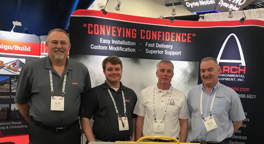 A group of men are standing in front of a sign that says conveying confidence.