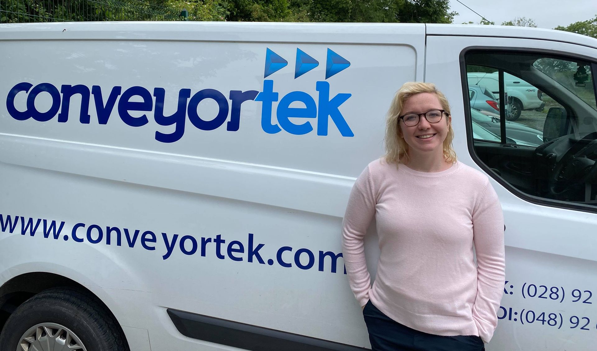 A woman is standing in front of a conveyortek van.