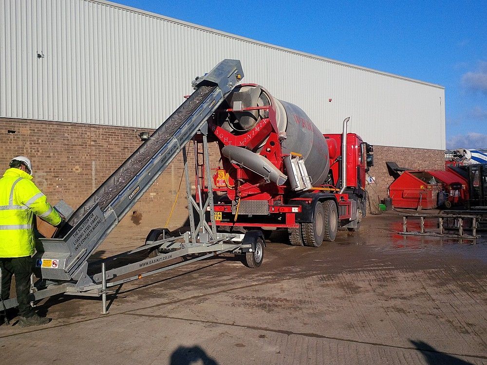 A conveyor belt is attached to a concrete mixer truck