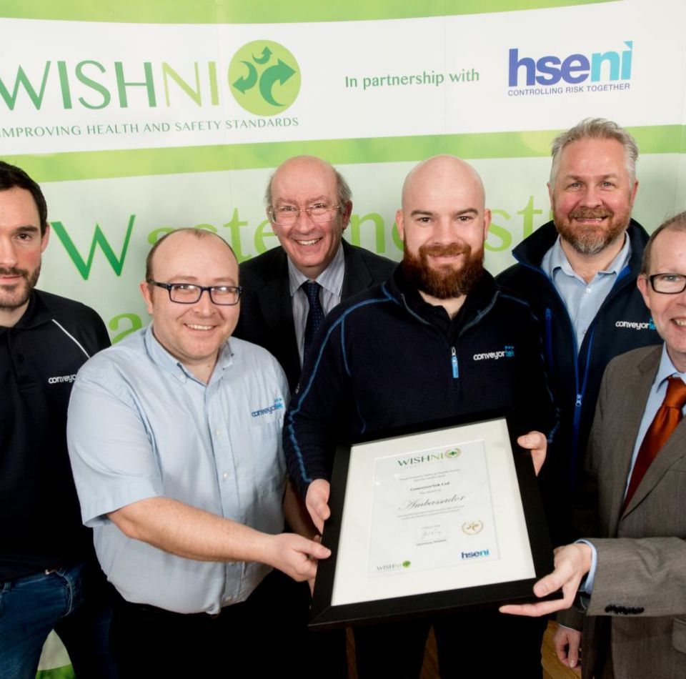 A group of men standing in front of a sign that says wishni