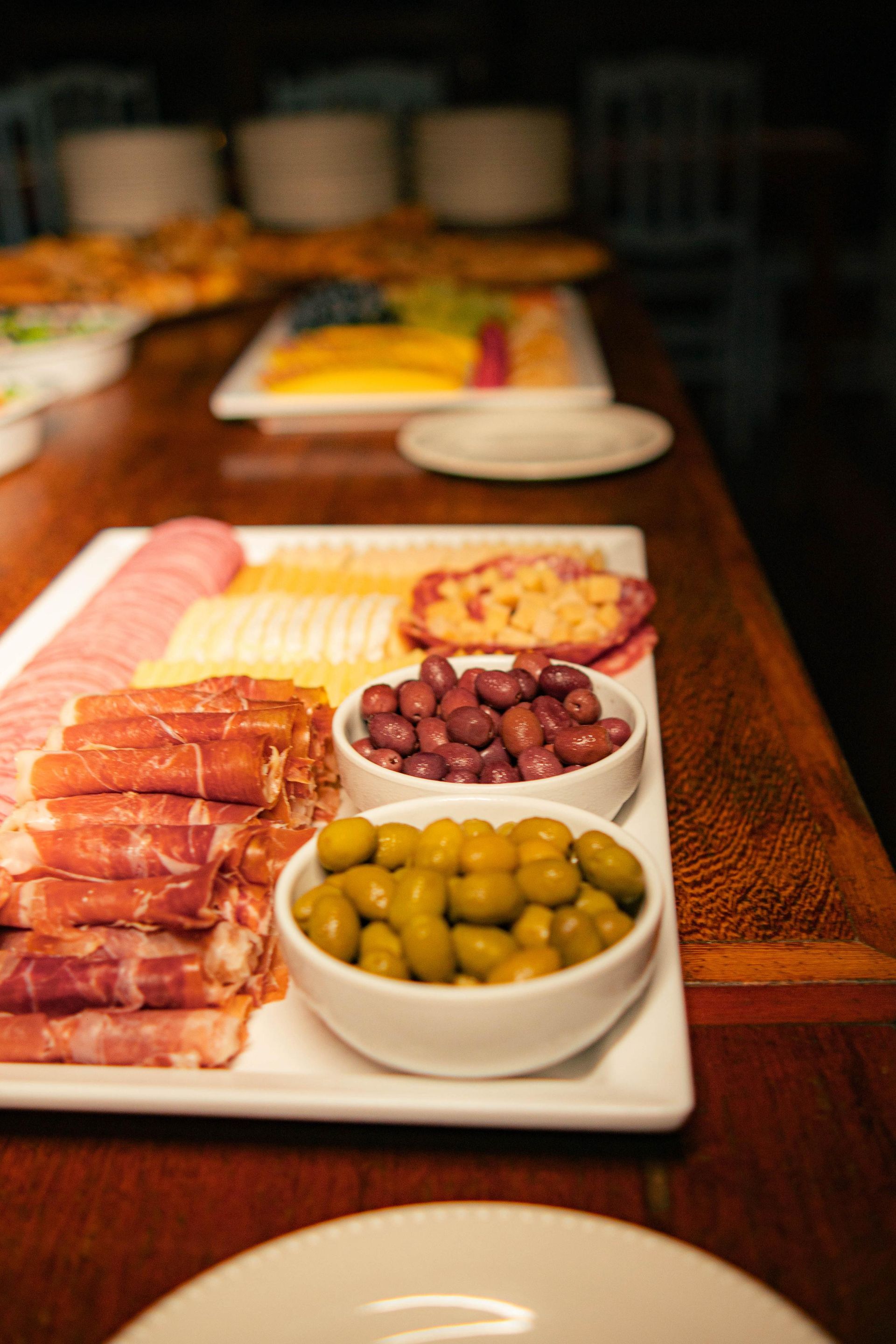 Uma mesa coberta com pratos de comida e tigelas de azeitonas.