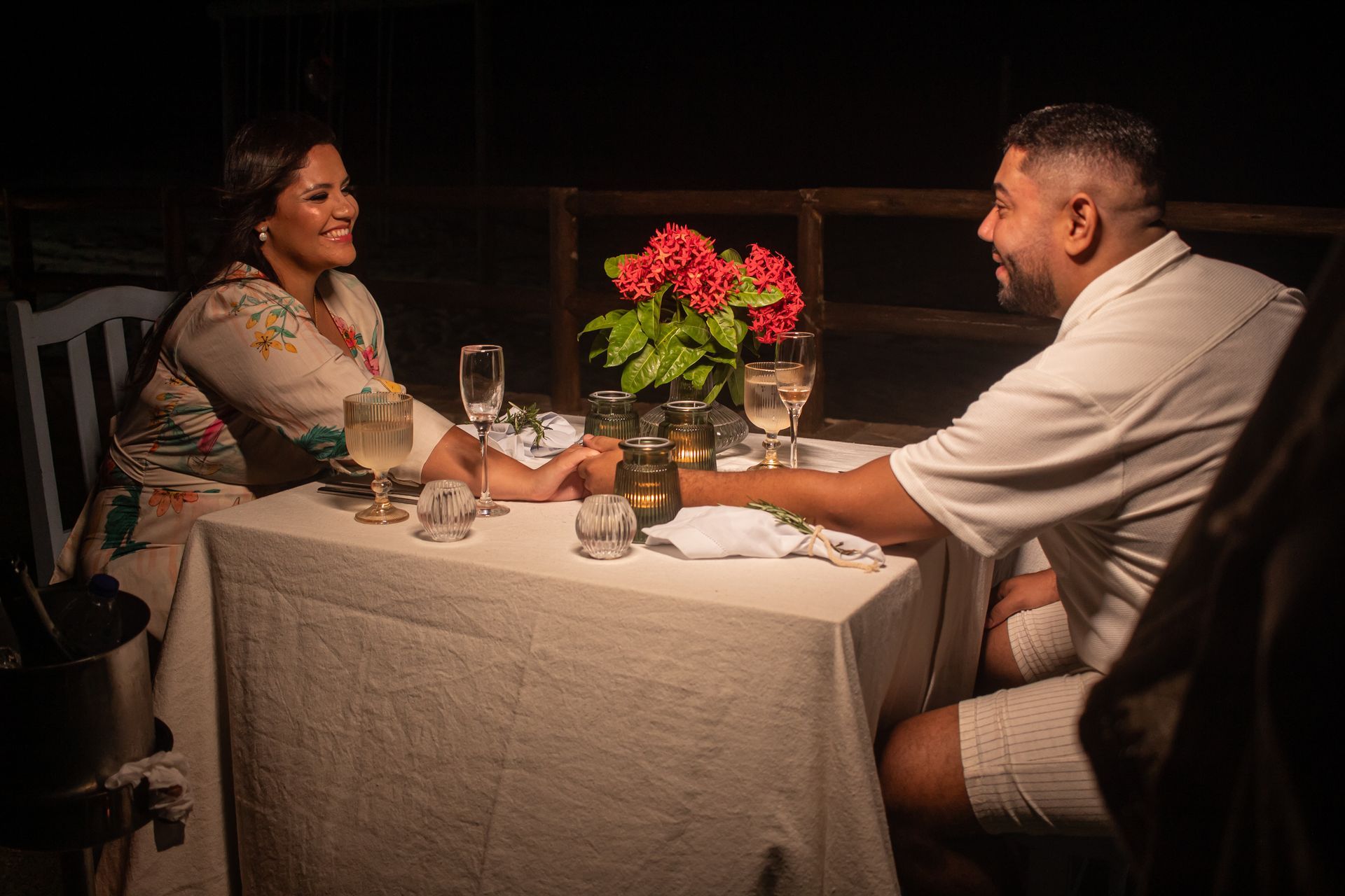 Um homem e uma mulher estão sentados à mesa de mãos dadas.