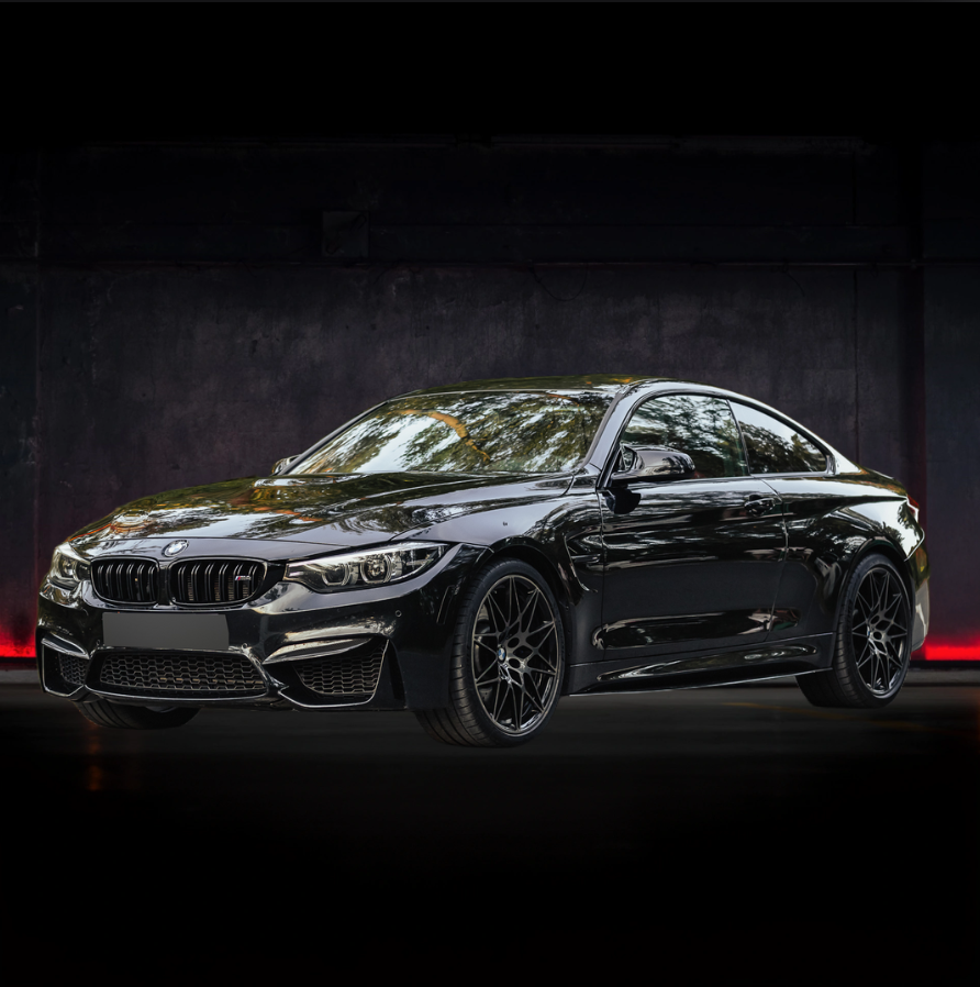 Una bmw m4 nera è parcheggiata in un garage buio.