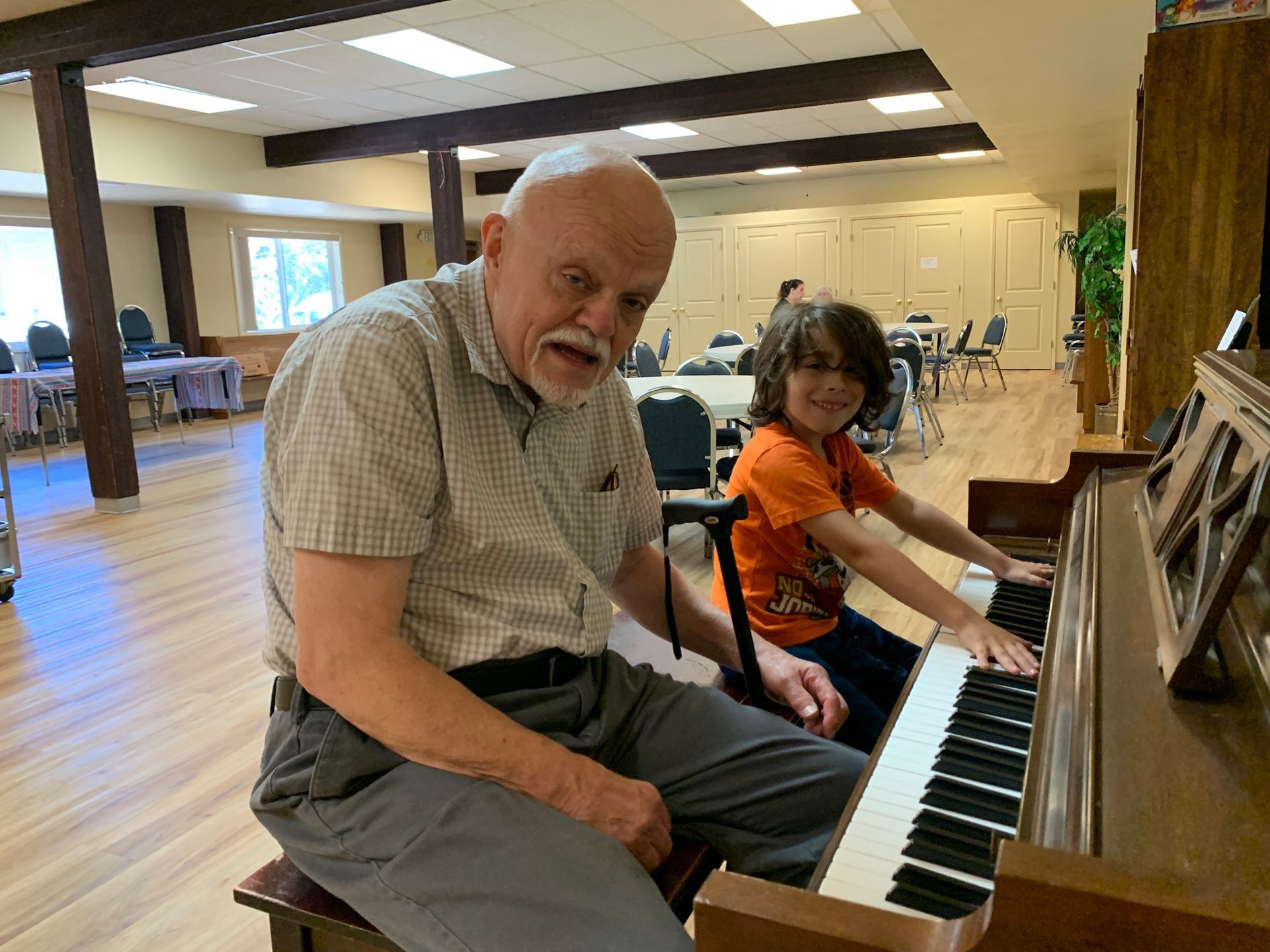 Elder and younger parishioner at a piano together