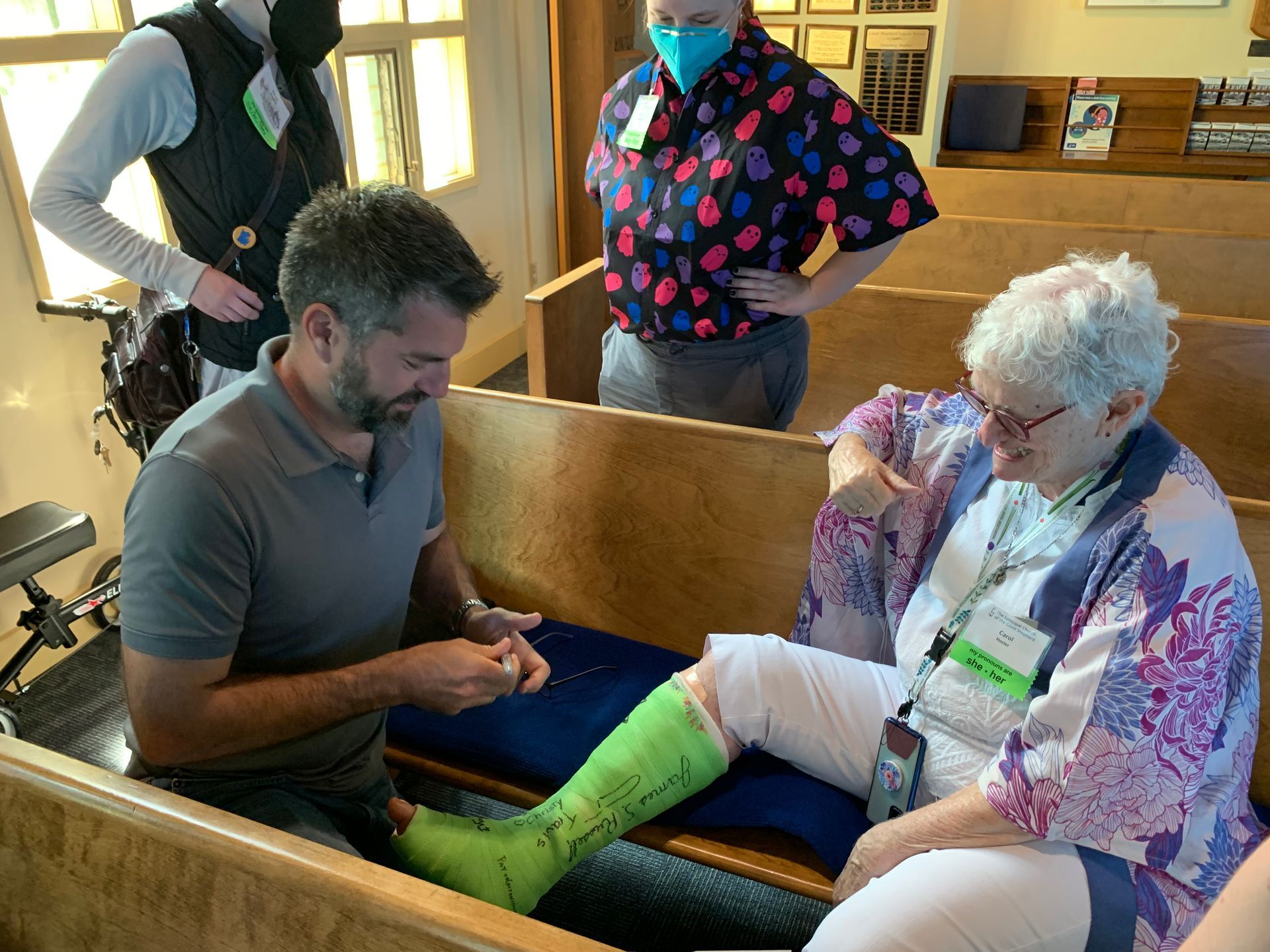 One parishioner signs another's leg cast