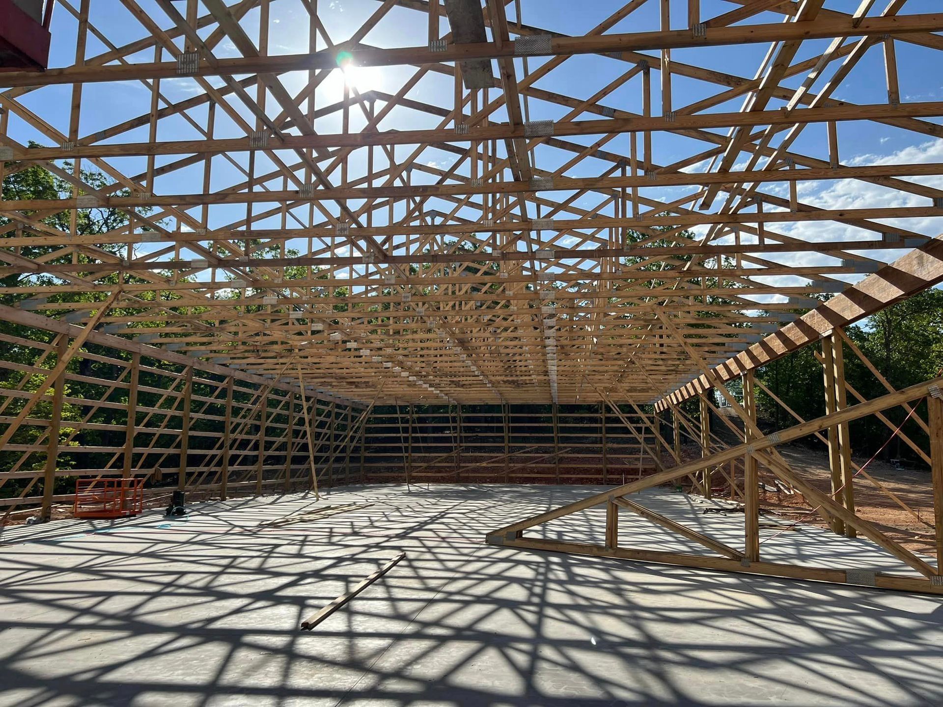 The sun is shining through the roof of a building under construction.