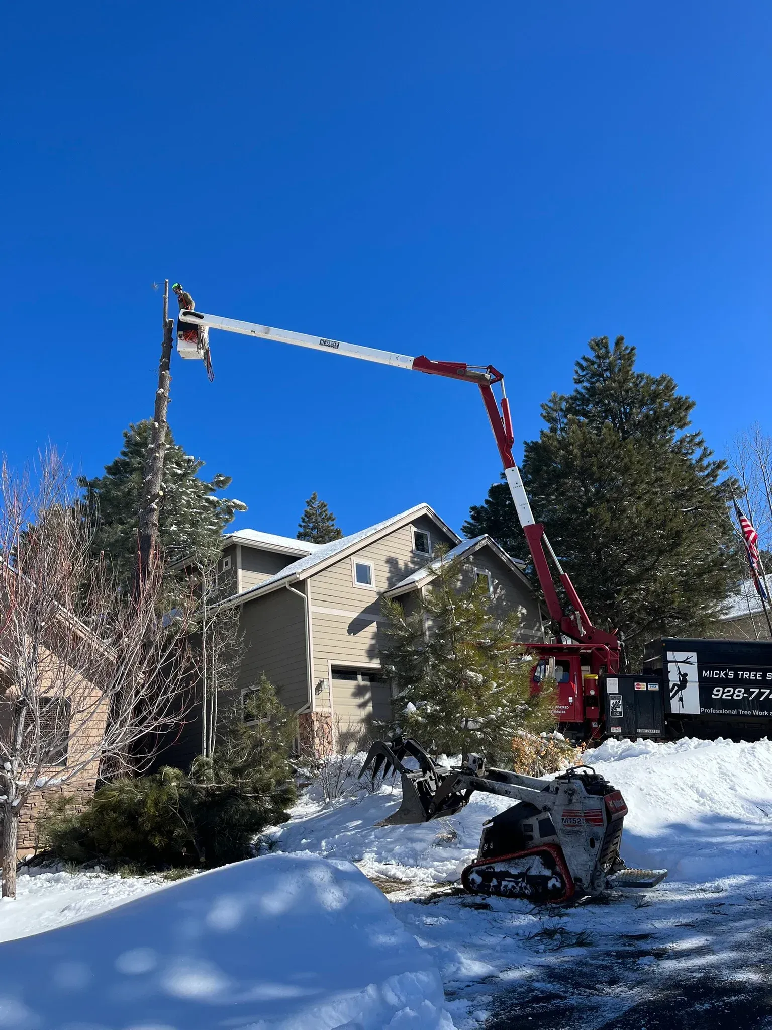 Red bucket truck for Nick's Tree Service with company phone number on the side, parked outdoors.