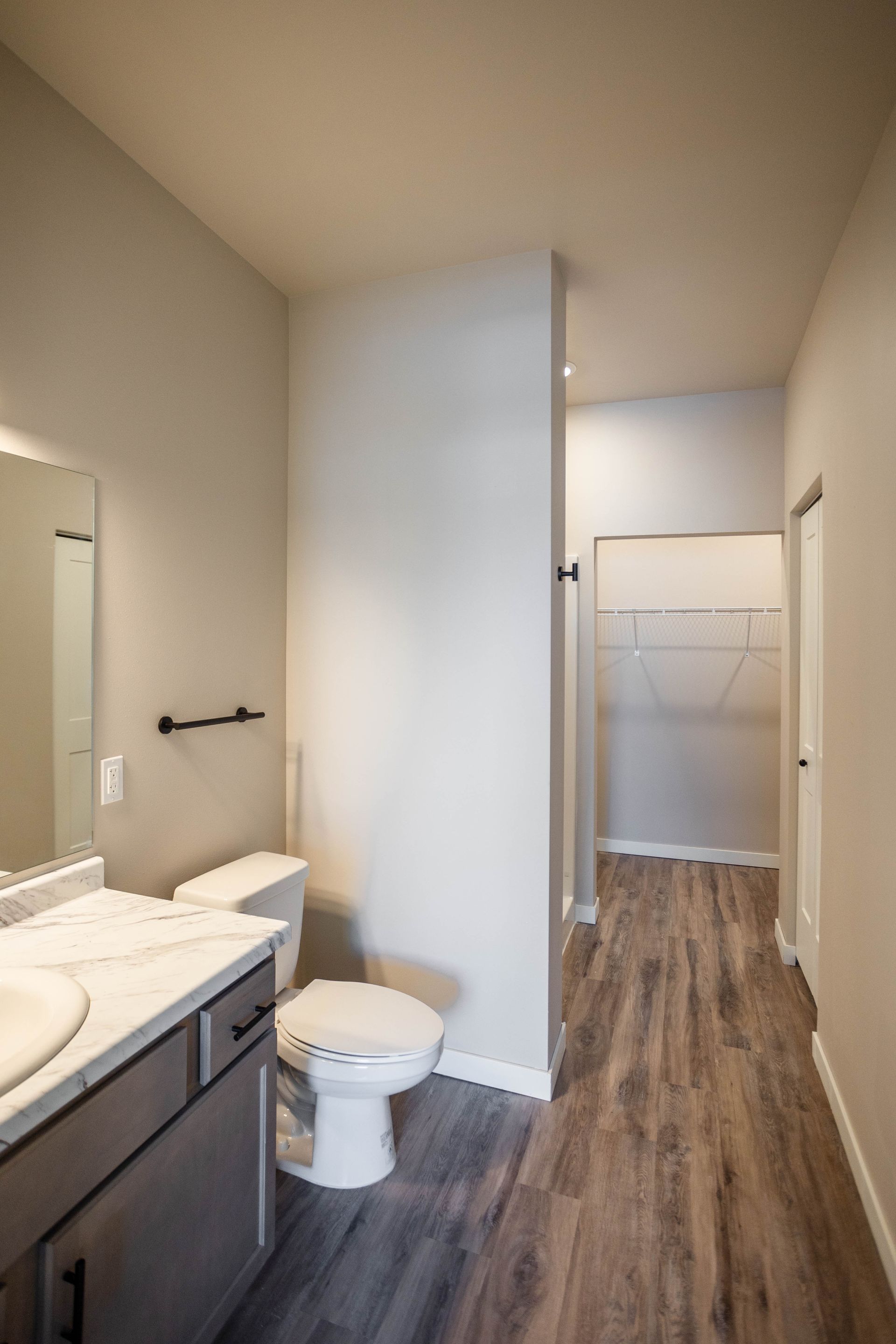 A bathroom with a toilet , sink and mirror.