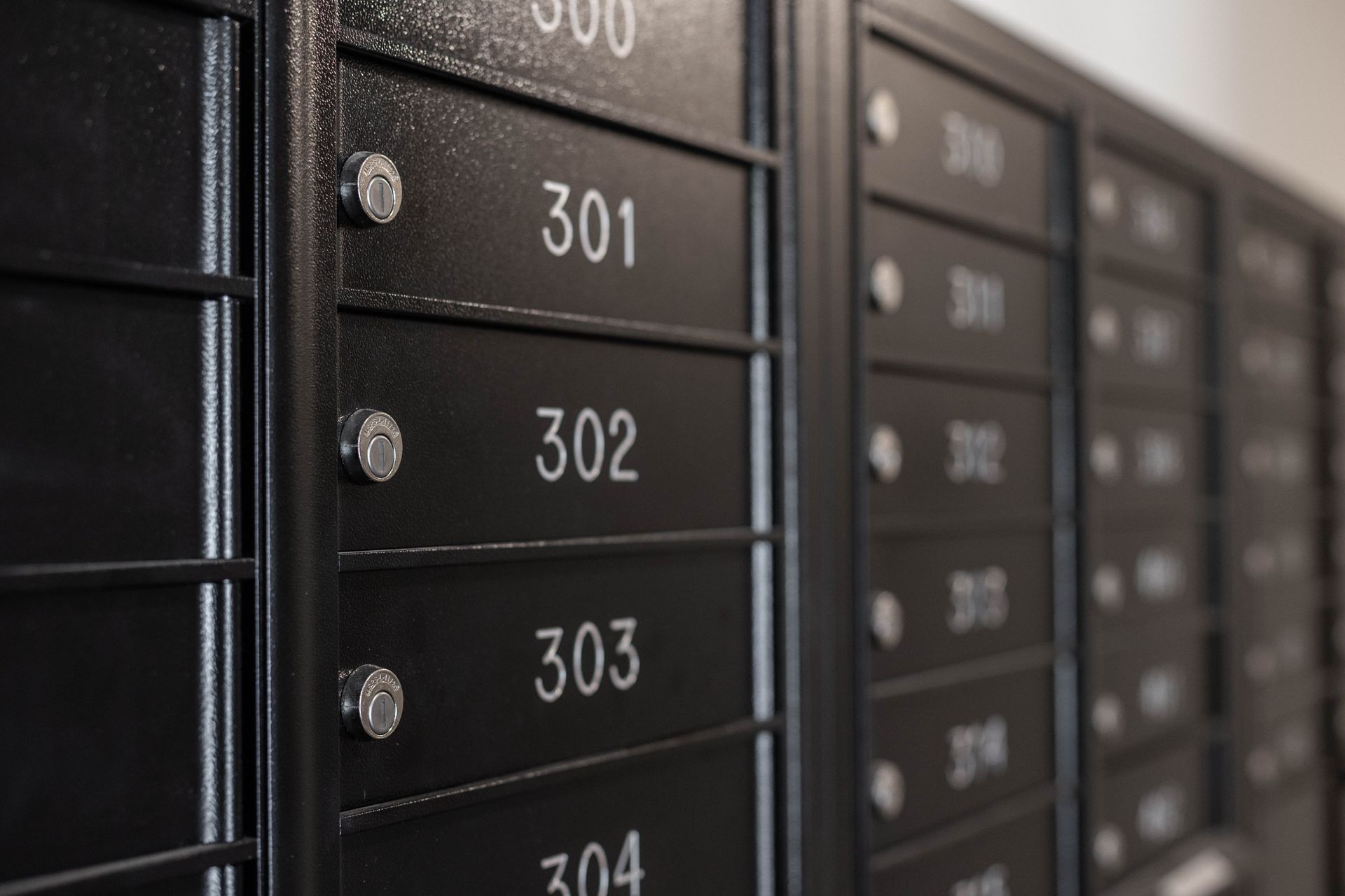 A row of mailboxes with the numbers 301 302 303 and 304 on them