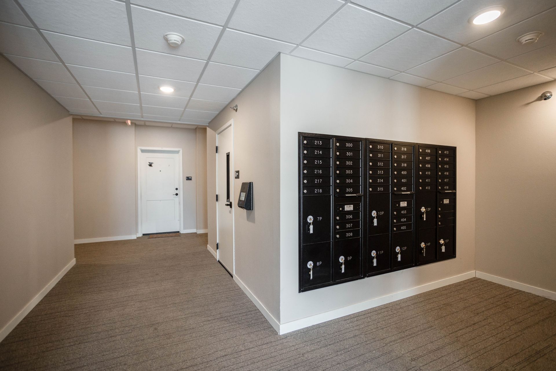 A hallway with a bunch of mailboxes on the wall
