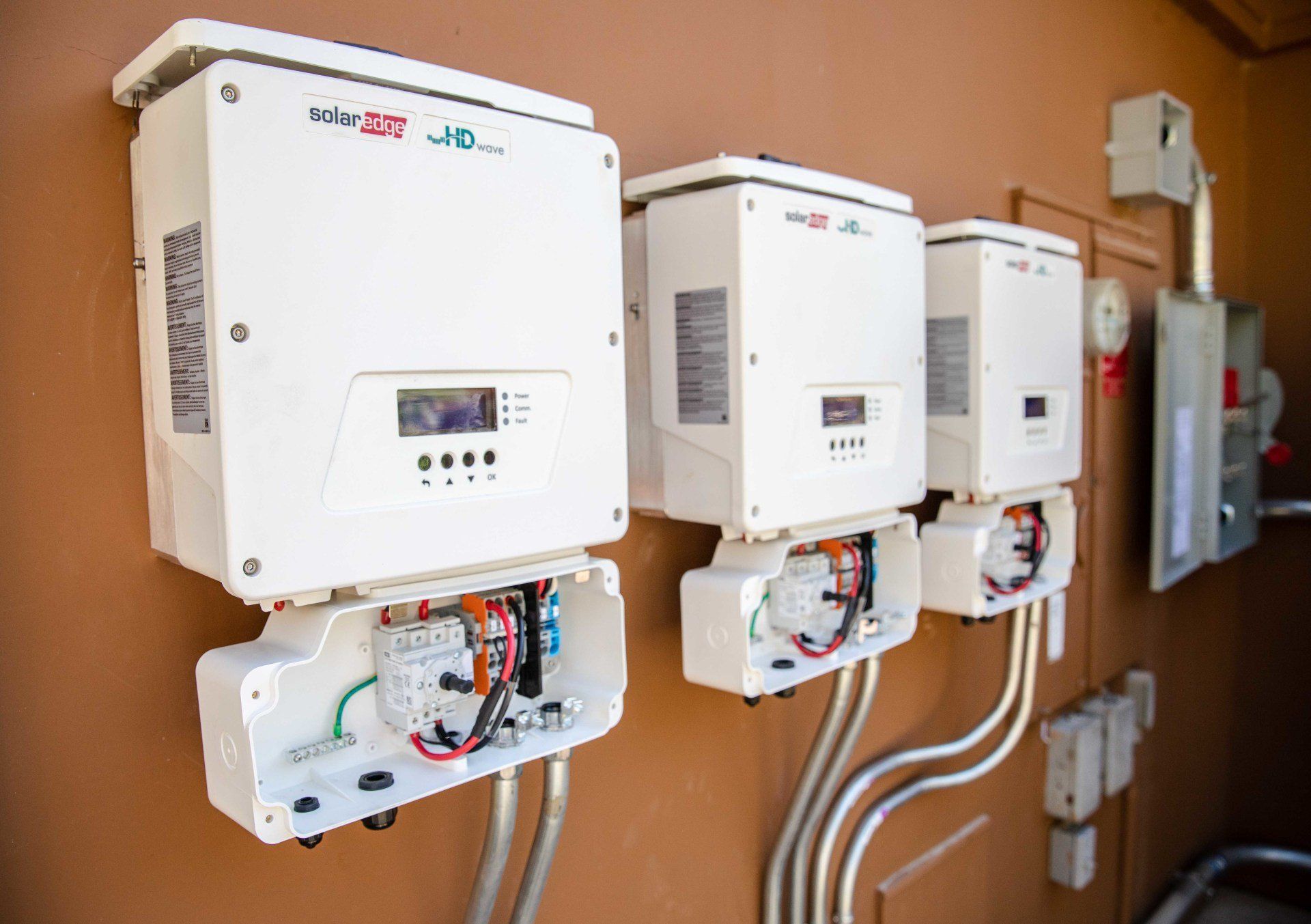 Wall-mounted electrical inverters and control units with wiring in a utility room