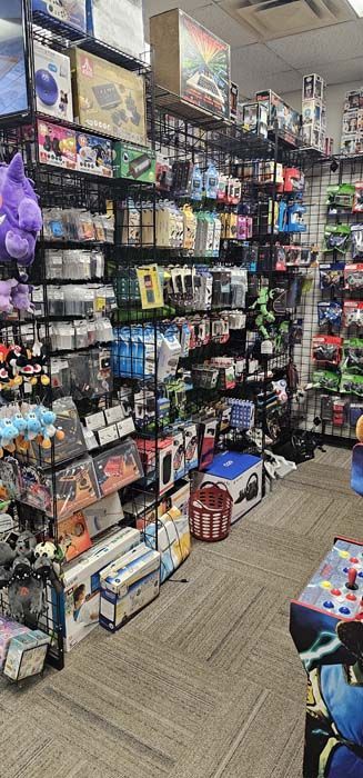 Inside a video rental store, movies line shelves and racks; a few customers.