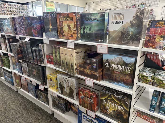 Shelves stocked with various board games in a brightly lit retail store.