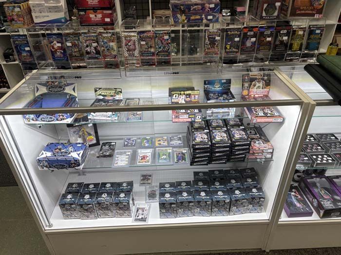 A display case filled with sports card packs, boxes, and memorabilia in a shop.