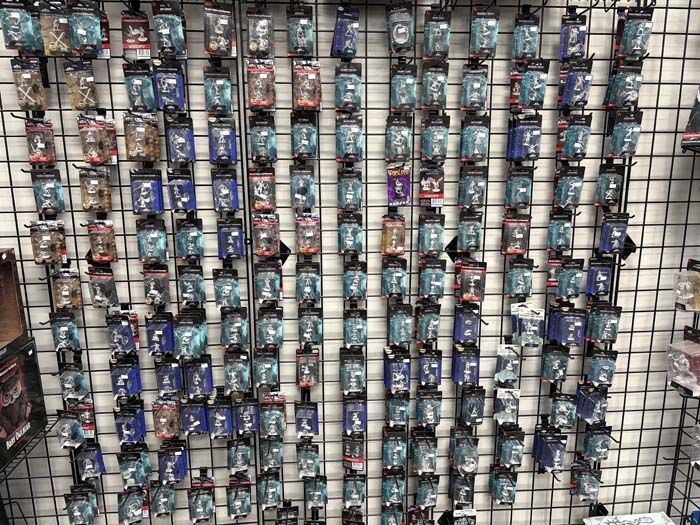 Wall display of packaged miniature figures, various colors and designs.