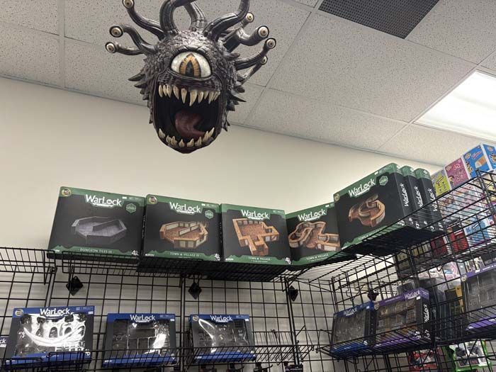 A Beholder statue hangs above store shelves displaying 