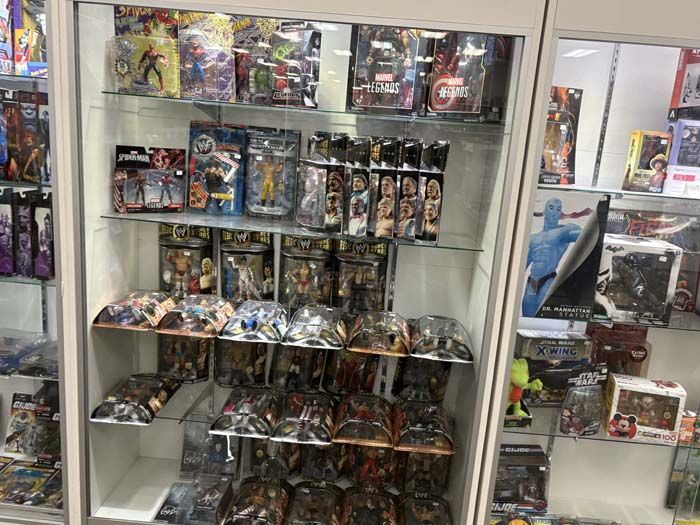 Display case filled with action figures, comic books, and collectibles in a store.