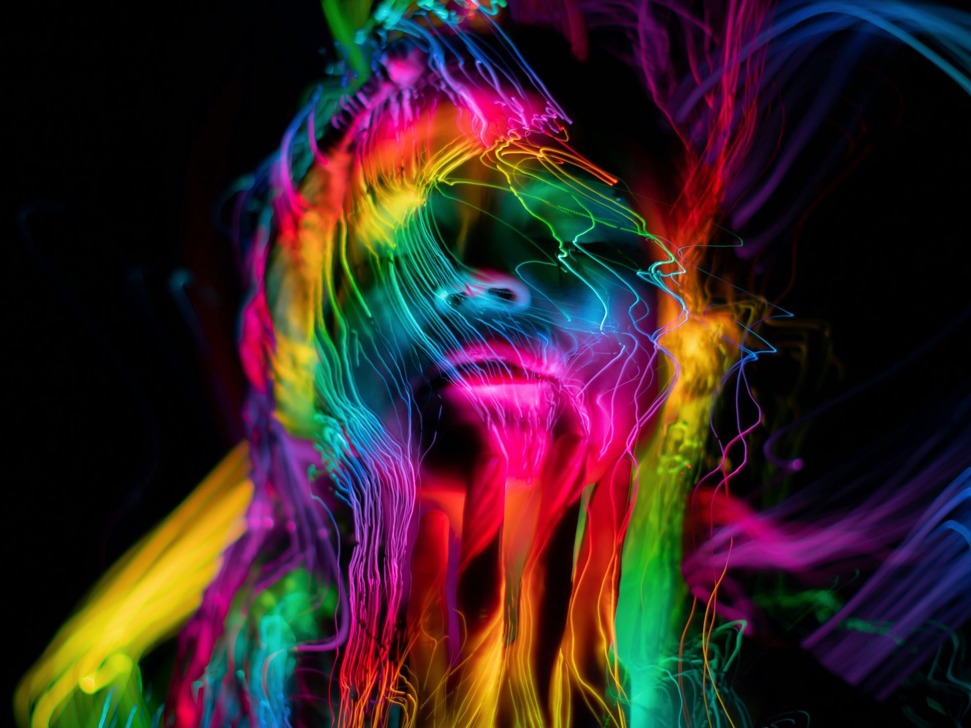 A woman 's face is surrounded by colorful lights on a black background.