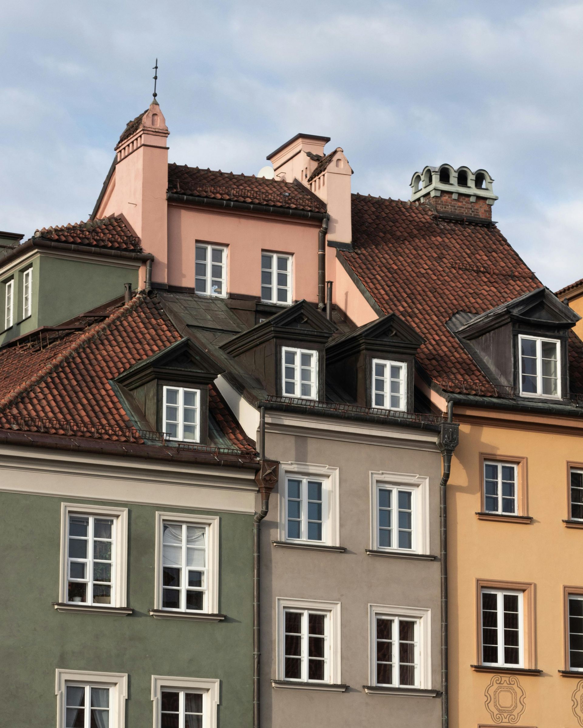 A row of buildings with different colors and roofs