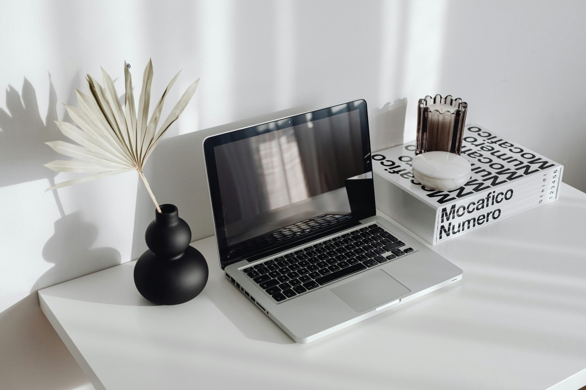 A laptop computer is sitting on top of a white desk.