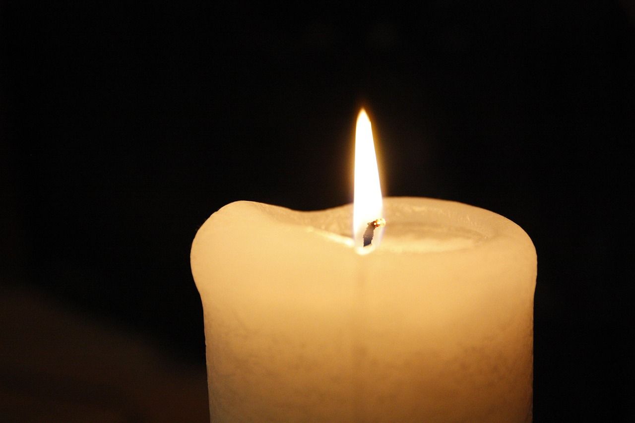 Memorial Candle Burning Softly in a Dark Setting